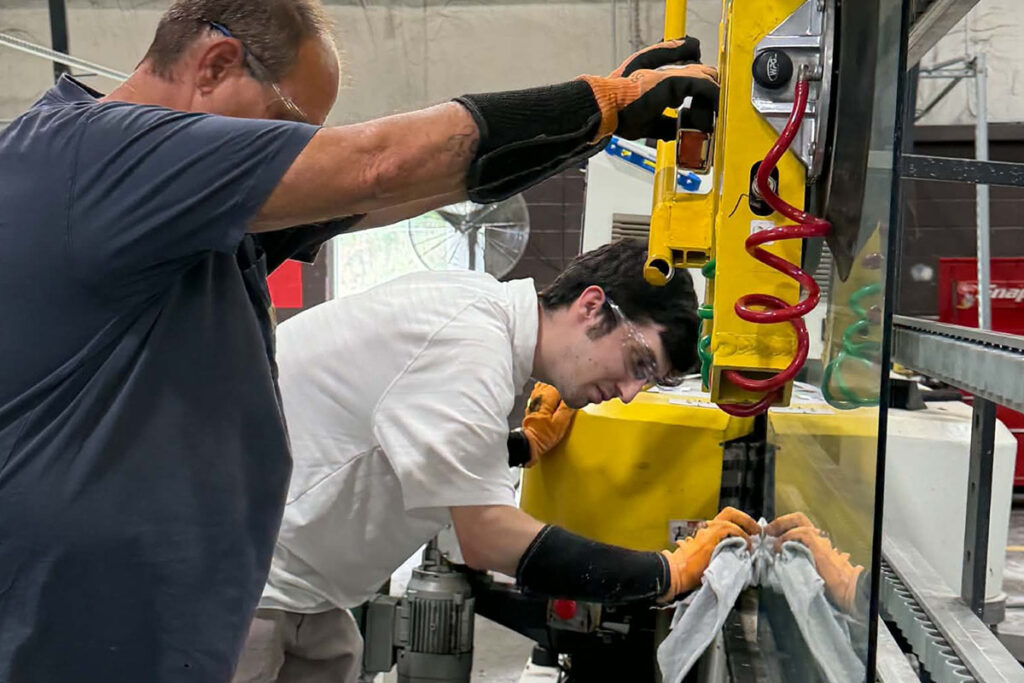 employees moving glass at a glass and mirror manufacturing plant