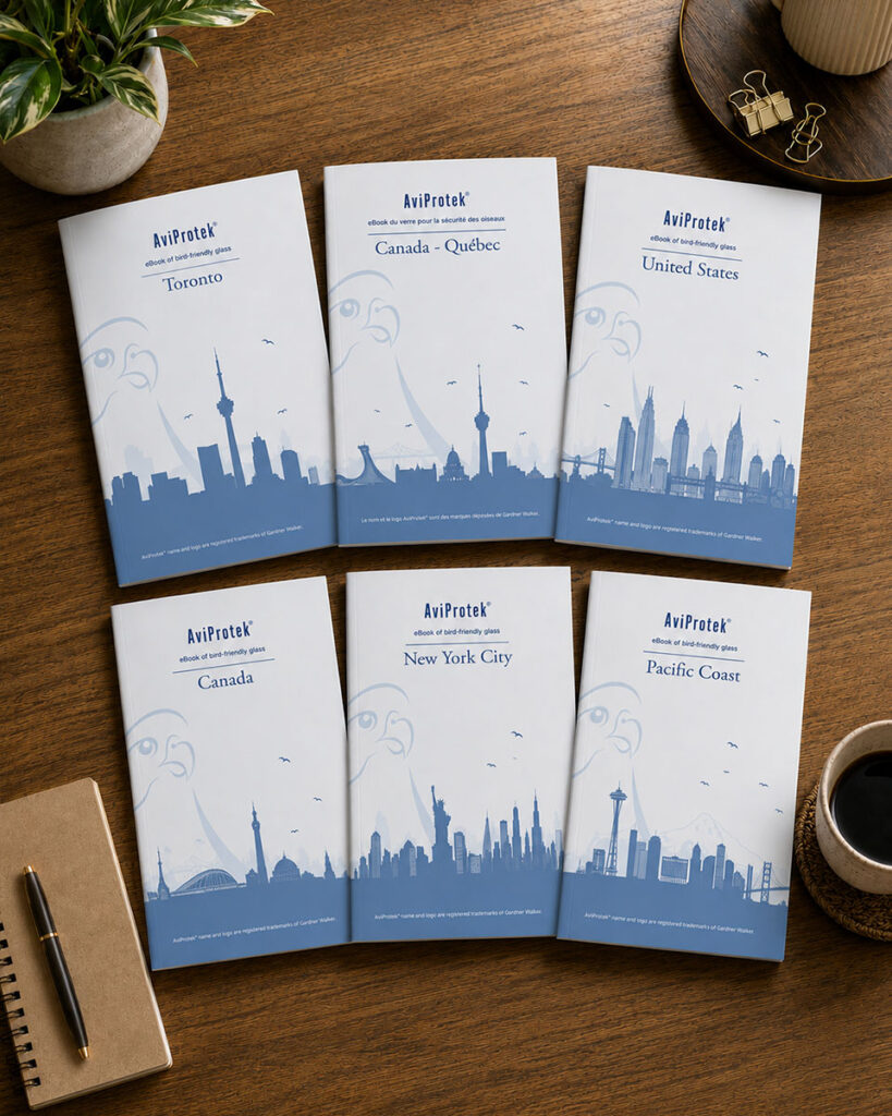 Aperçu de six livres numériques Aviprotek sur le verre adapté aux oiseaux, posés sur un bureau en bois (format vertical)